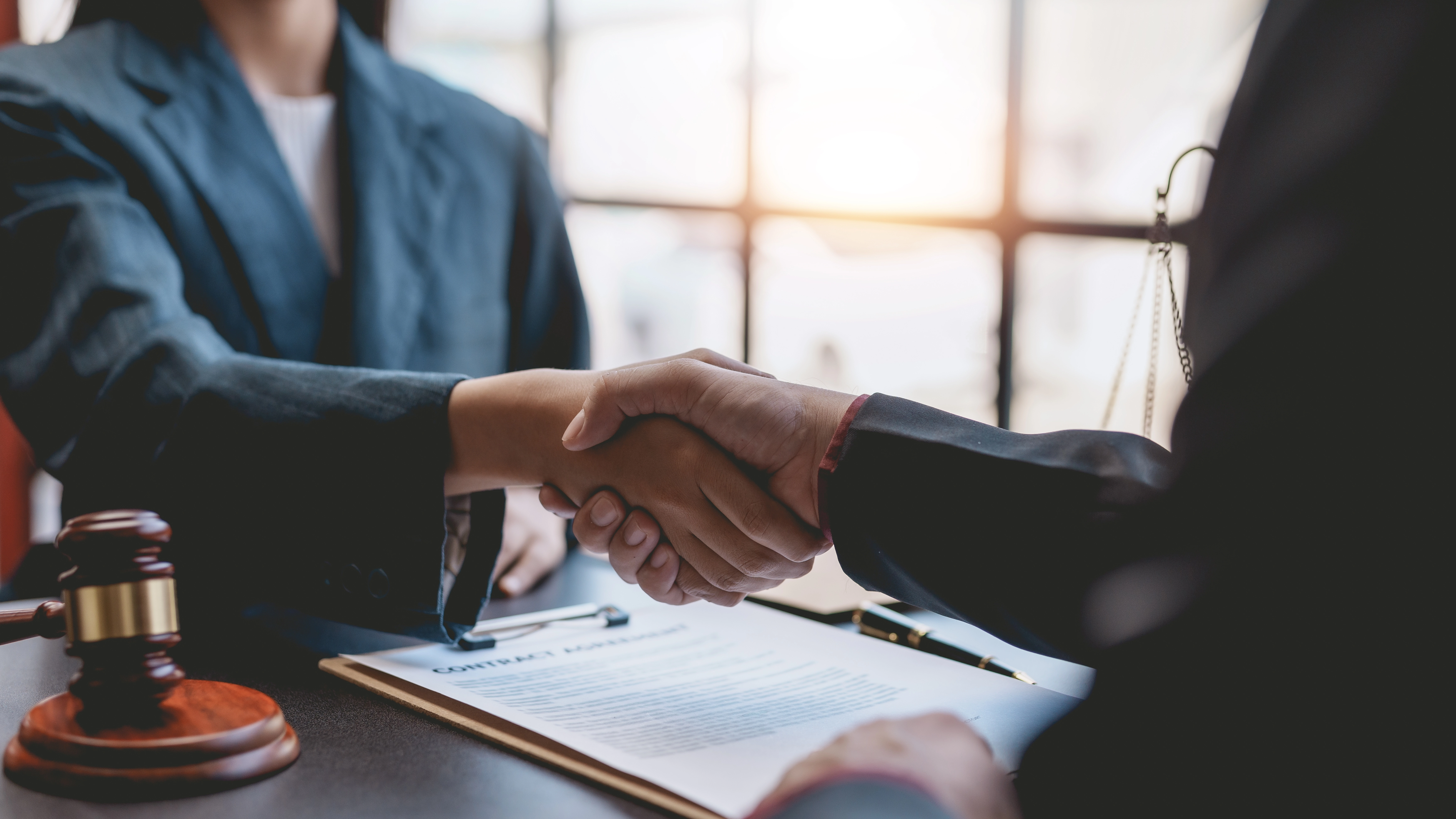 lawyers shaking hands coming into agreement over decision